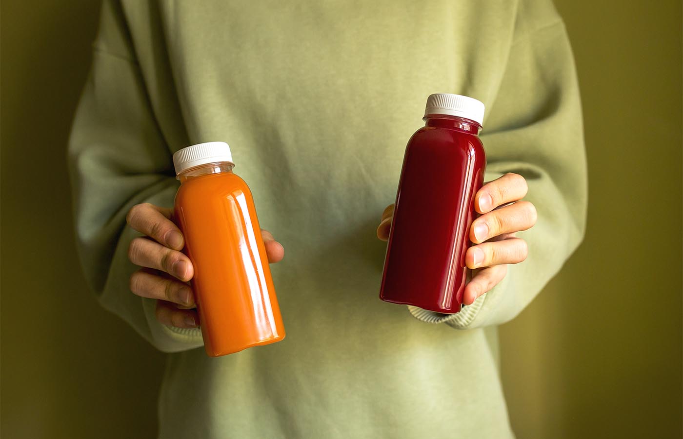 A woman holding two bottles of juice
